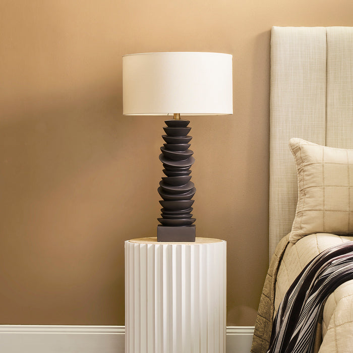 Modern [Brand] lamp on textured table, beige bedroom decor.