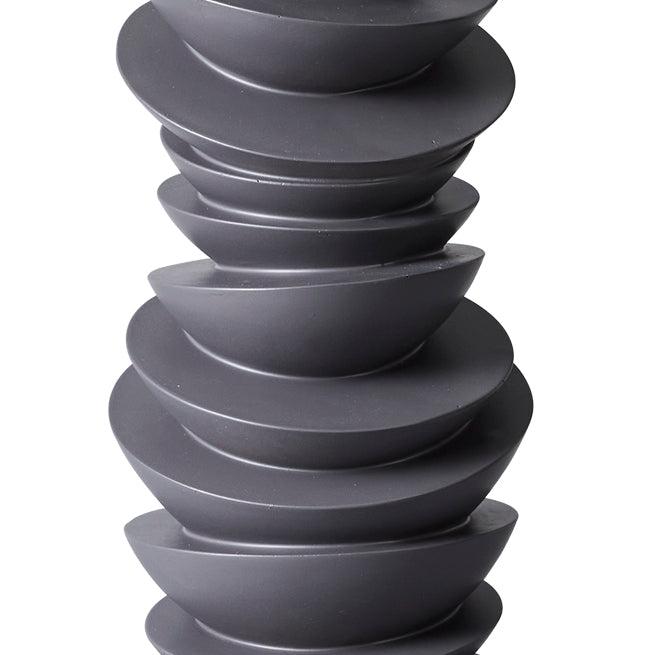 Stacked black bowls forming a unique sculpture by [Brand].