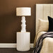 Modern [Brand] lamp on stylish white bedside table, bedroom setting.