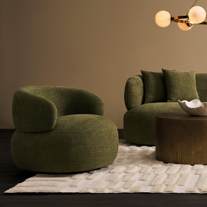 Olive green [Brand] furniture with rug, table, and chandelier.