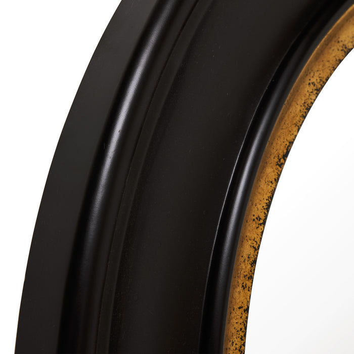 Close-up of [Brand] black and gold circular mirror frame.