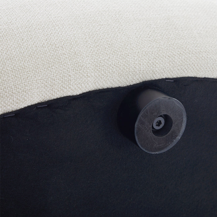 [Brand] ottoman underside close-up showing fabric and leg.