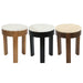Three [Brand] round stools with diverse wooden finishes displayed.