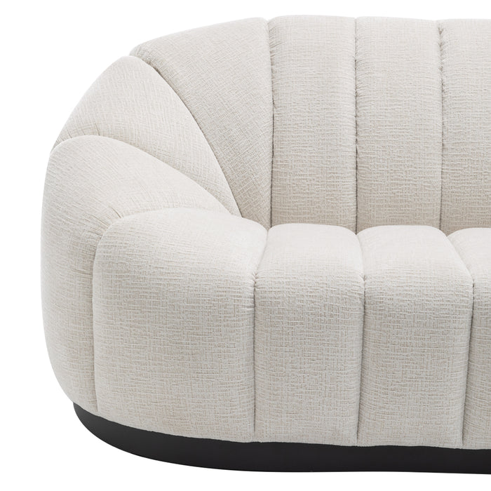 [Brand] white tufted sofa with curved, textured upholstery design.