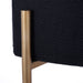 [Brand] chair leg with black fabric and gold finish.