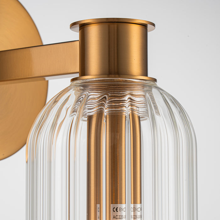 [Brand] brass and glass wall light with ribbed details.