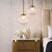 [Brand] bedroom setup with elegant pendant lights and decor.