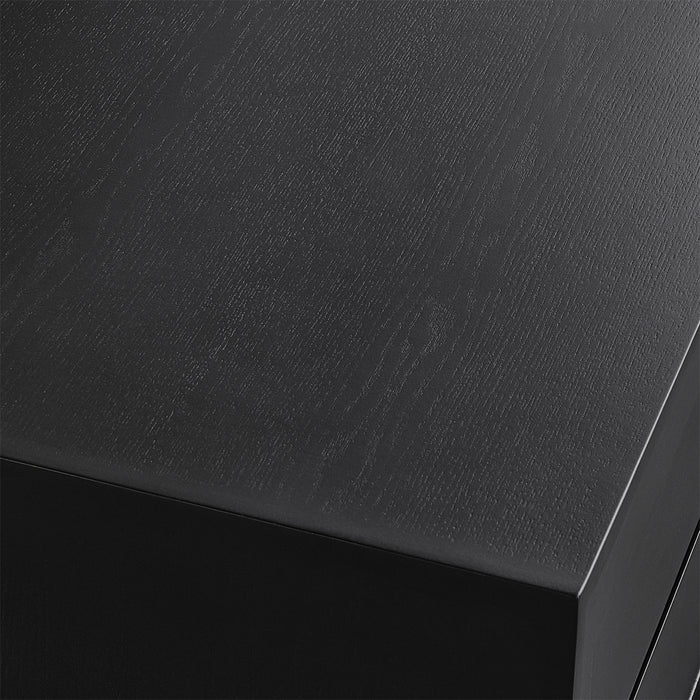 [Brand] black wooden desk corner with visible grain texture.