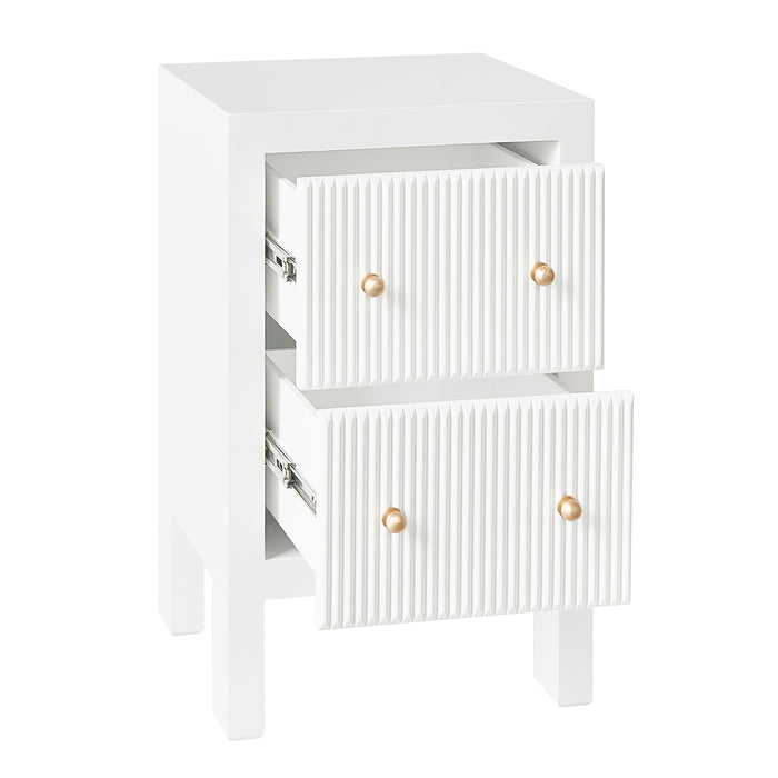 [Brand] white nightstand with ribbed drawers and gold knobs.