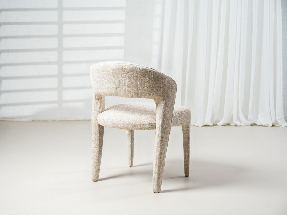 [Brand] elegant beige chair with curved backrest, minimalist design.
