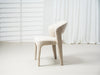 Modern beige upholstered chair against light background by [Brand].