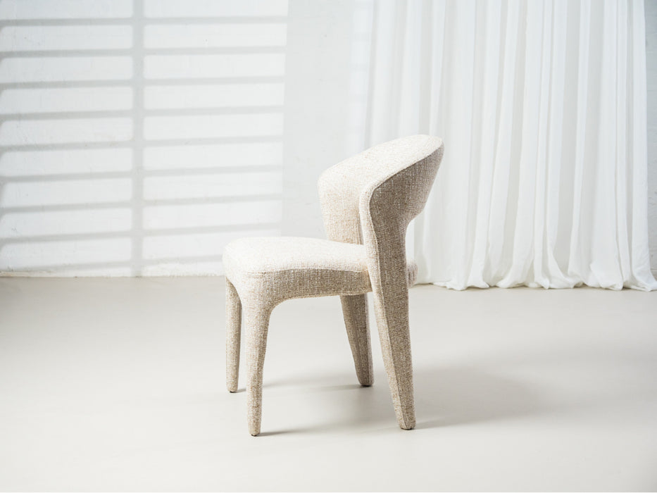 Modern beige upholstered chair against light background by [Brand].