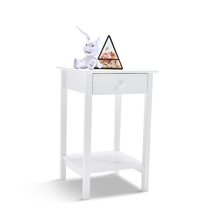 White [Brand] table with plush toy and pyramid decor.