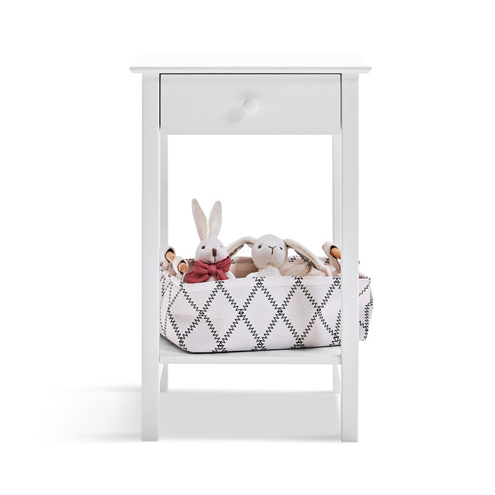 White [Brand] table with drawer, basket, and fabric bunnies.